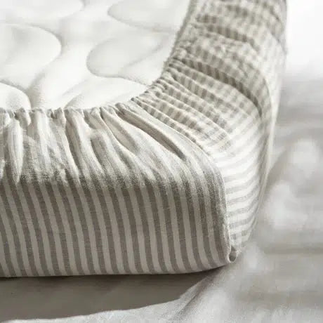 A Warren Hill french linen fitted cot sheet in white and gray.