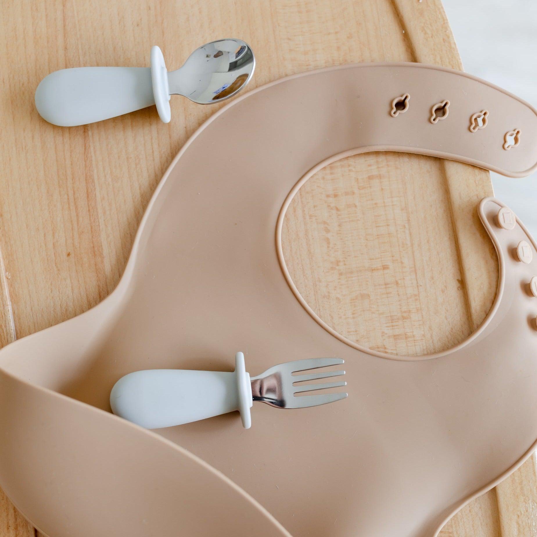 Encourage independence with a toddler cutlery set in beige bib featuring a fork and spoon, perfect for mealtime and curious little hands. (Brand: Rommer, Product: Cloud)
