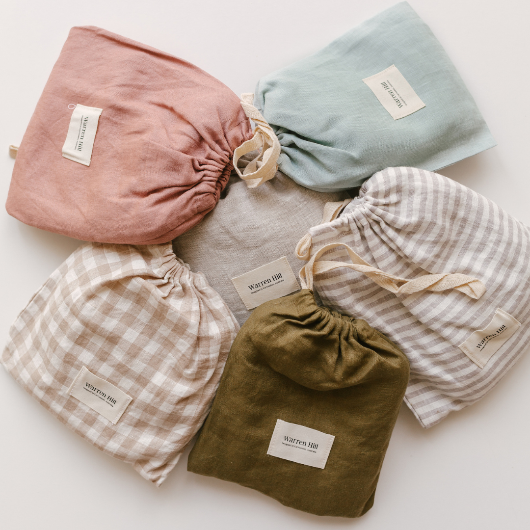 A variety of Warren Hill french linen fitted cot sheets in grey stripe colors and styles.