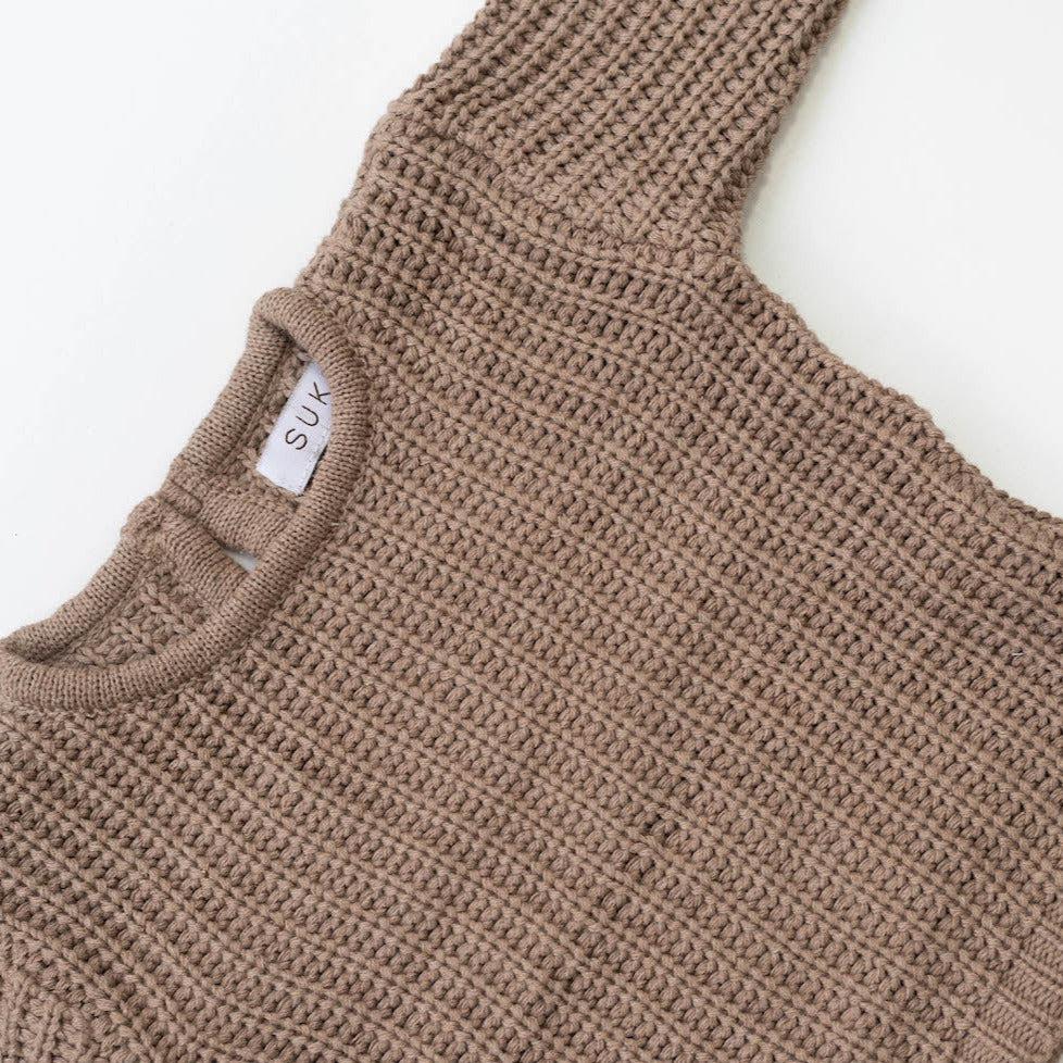The Zoa knit is lovingly handmade using a loom which is a tool that is guided by the hand. 100% soft cotton, teardrop fastening at back with wood button. Good amount of stretch, considered true to size described as more ‘fitted’.
