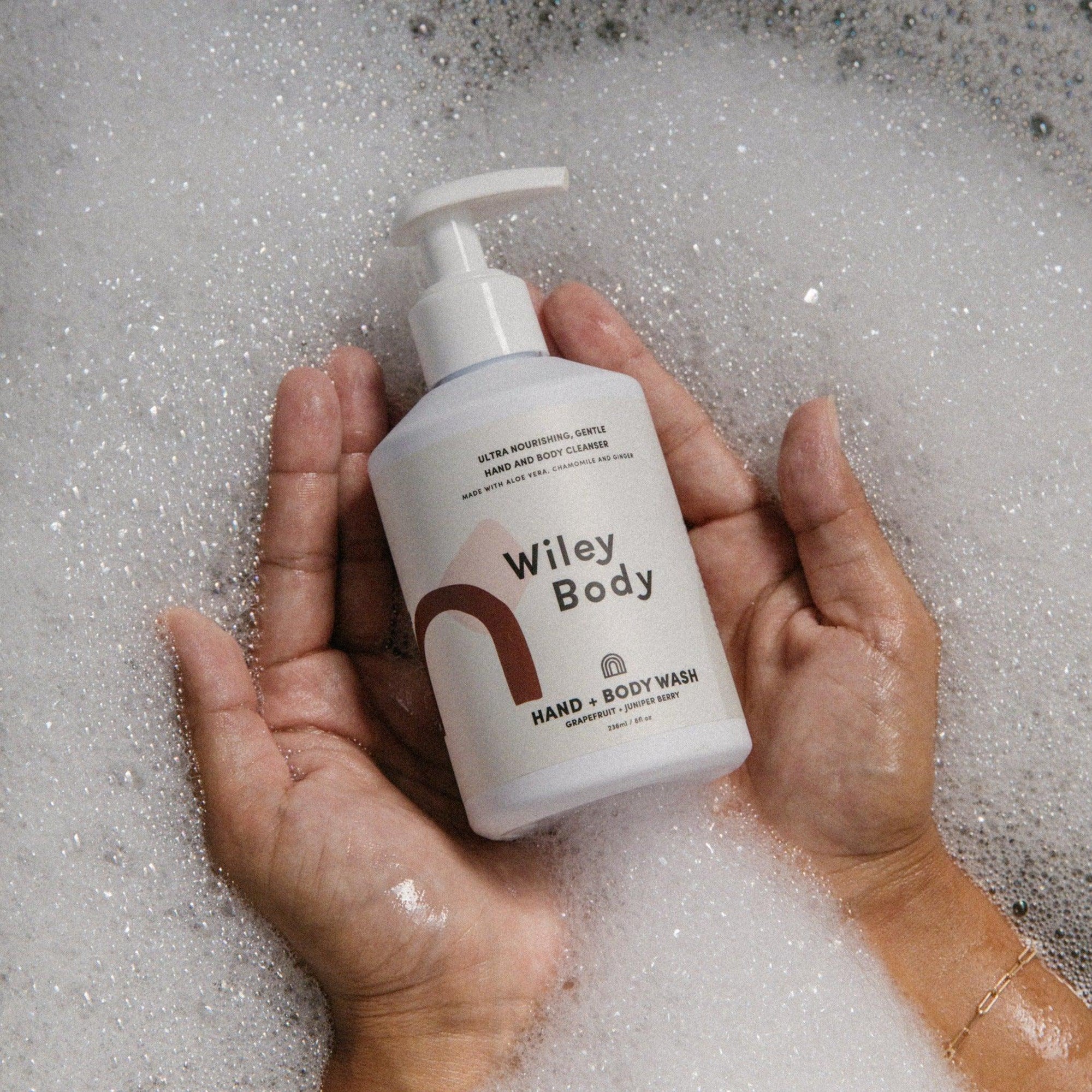 A person holding a bottle of Wiley Body organic whey body soap.