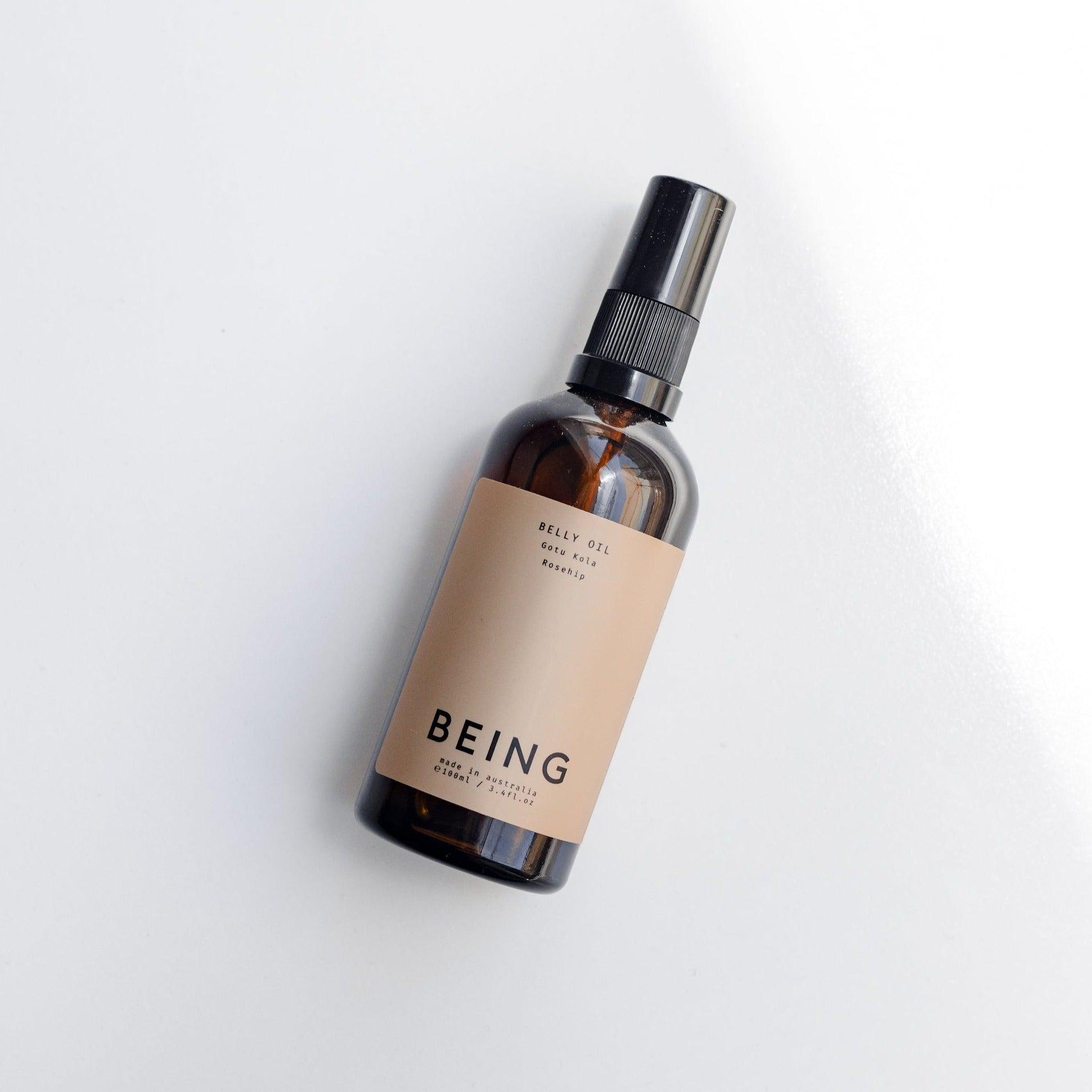 A bottle of Being Skincare Belly Oil on a white surface.